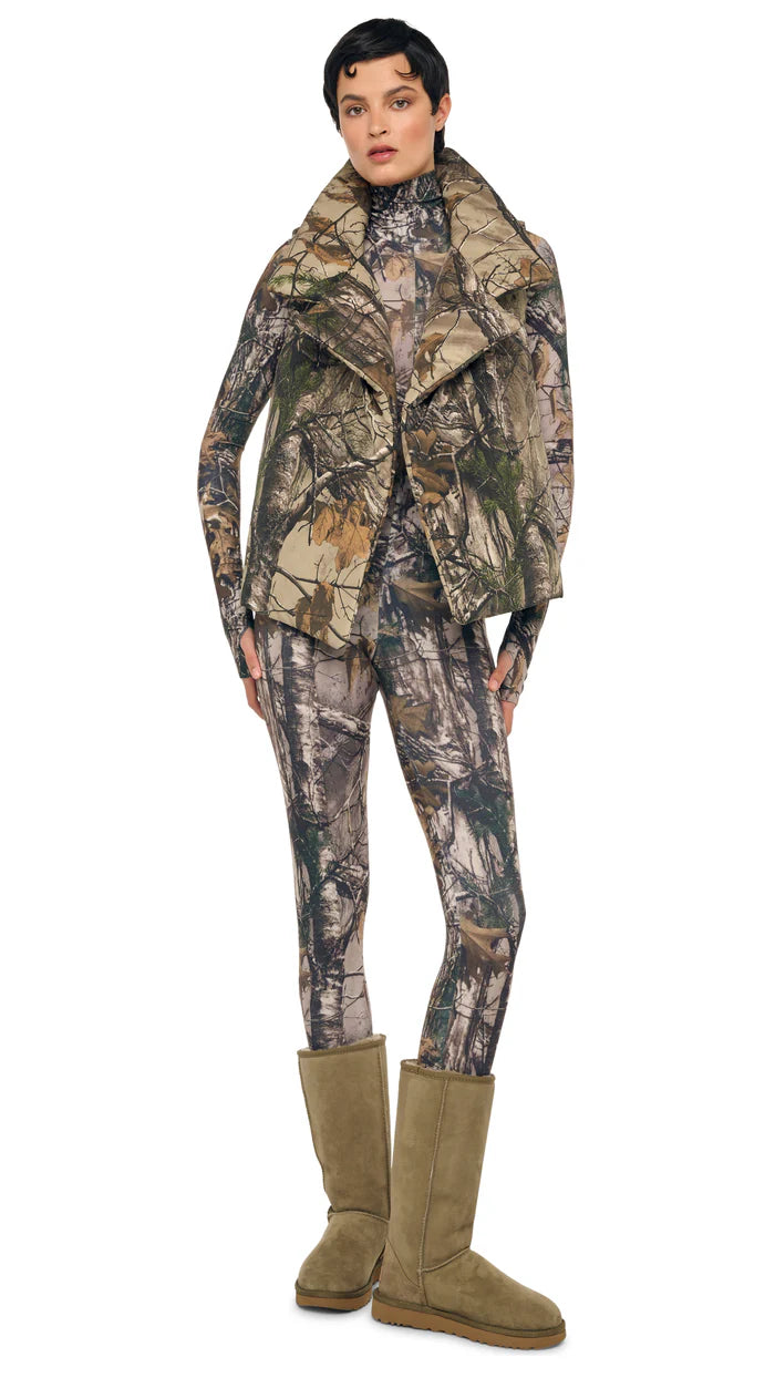 Model wearing Norma Kamali sleeveless Sleeping Bag Vest with wide lapels and self-tie belt