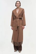 Load image into Gallery viewer, Simkhai Carrie full-length camel coat with dramatic shawl collar, self-tie belt, and fringed hem, crafted in a wool-blend fabric
