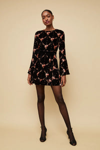 Model wearing Cara Cara Rosabella mini dress with velvet waist bow and bell sleeves