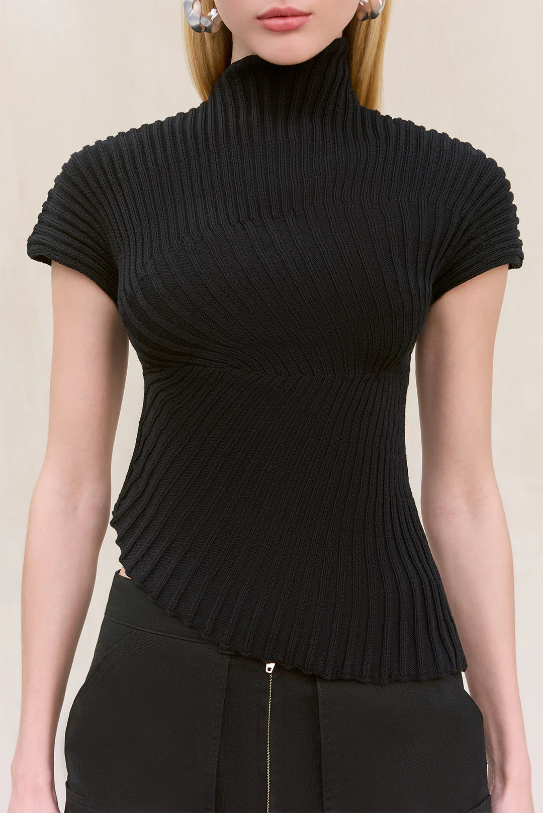 Cult Gaia Annemie Top — asymmetrical knit top with a mock neck, flared cap sleeves, and radial stitch detailing, featuring an uneven hem and a slightly relaxed fit.