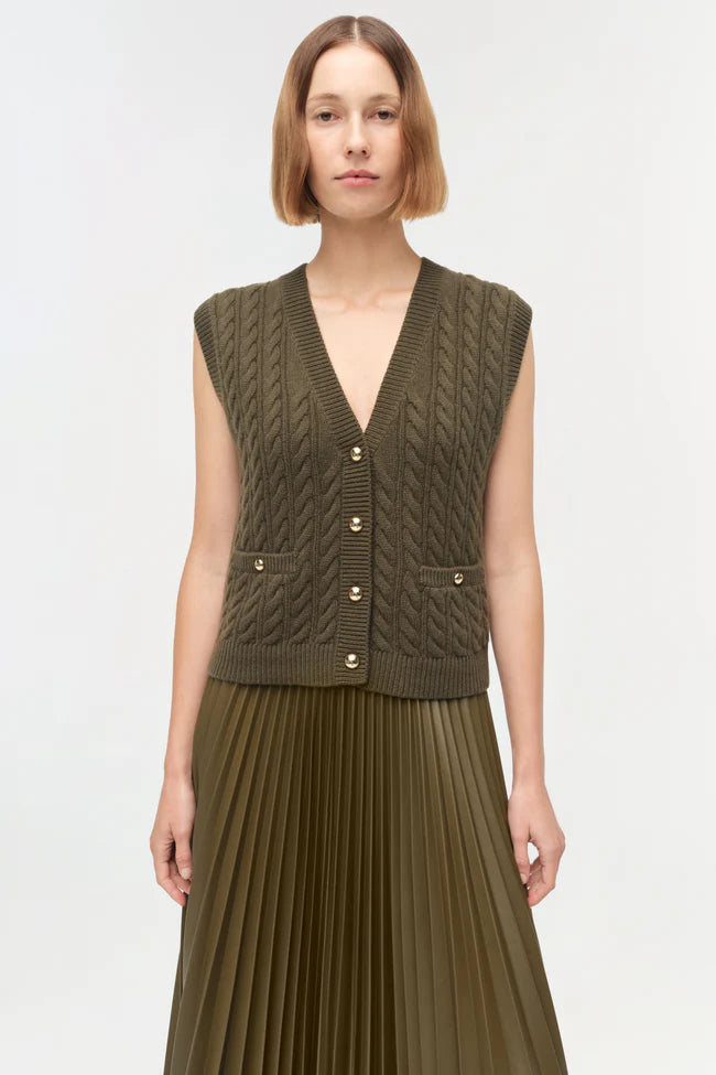 Model wearing Simkhai Perrie Cashmere Vest in olive with cable knit texture and gold-tone buttons