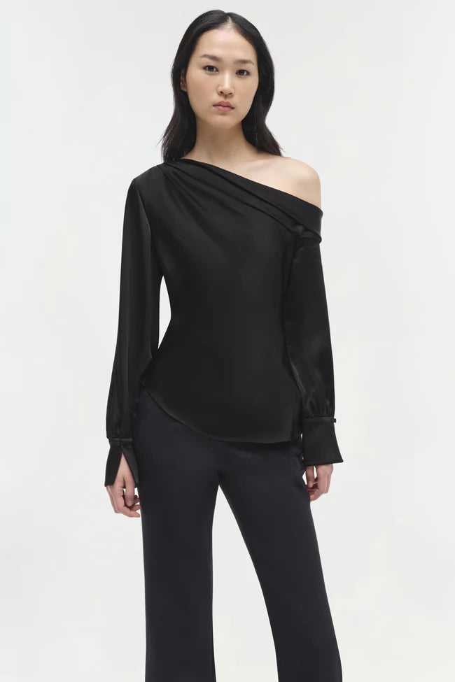 Model wearing Simkhai Alice Cold Shoulder Top in black satin with elegant draping