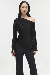 Model wearing Simkhai Alice Cold Shoulder Top in black satin with elegant draping