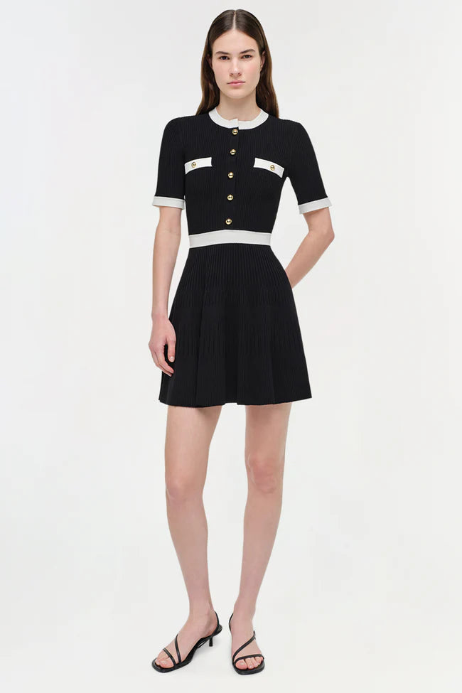 Model wearing Simkhai Astoria Dress with ivory trim, gold buttons, and flared mini skirt