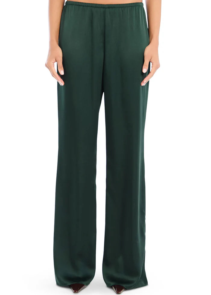 Model wearing Seroya Viva Satin Pants in Evergreen – mid-rise, wide-leg satin trousers with elastic waistband.