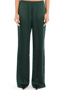Model wearing Seroya Viva Satin Pants in Evergreen – mid-rise, wide-leg satin trousers with elastic waistband.