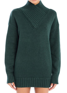 Model wearing Seroya Dessa Chunky Knit Sweater Dress in Evergreen – oversized chunky knit with high neck, styled as a dress.