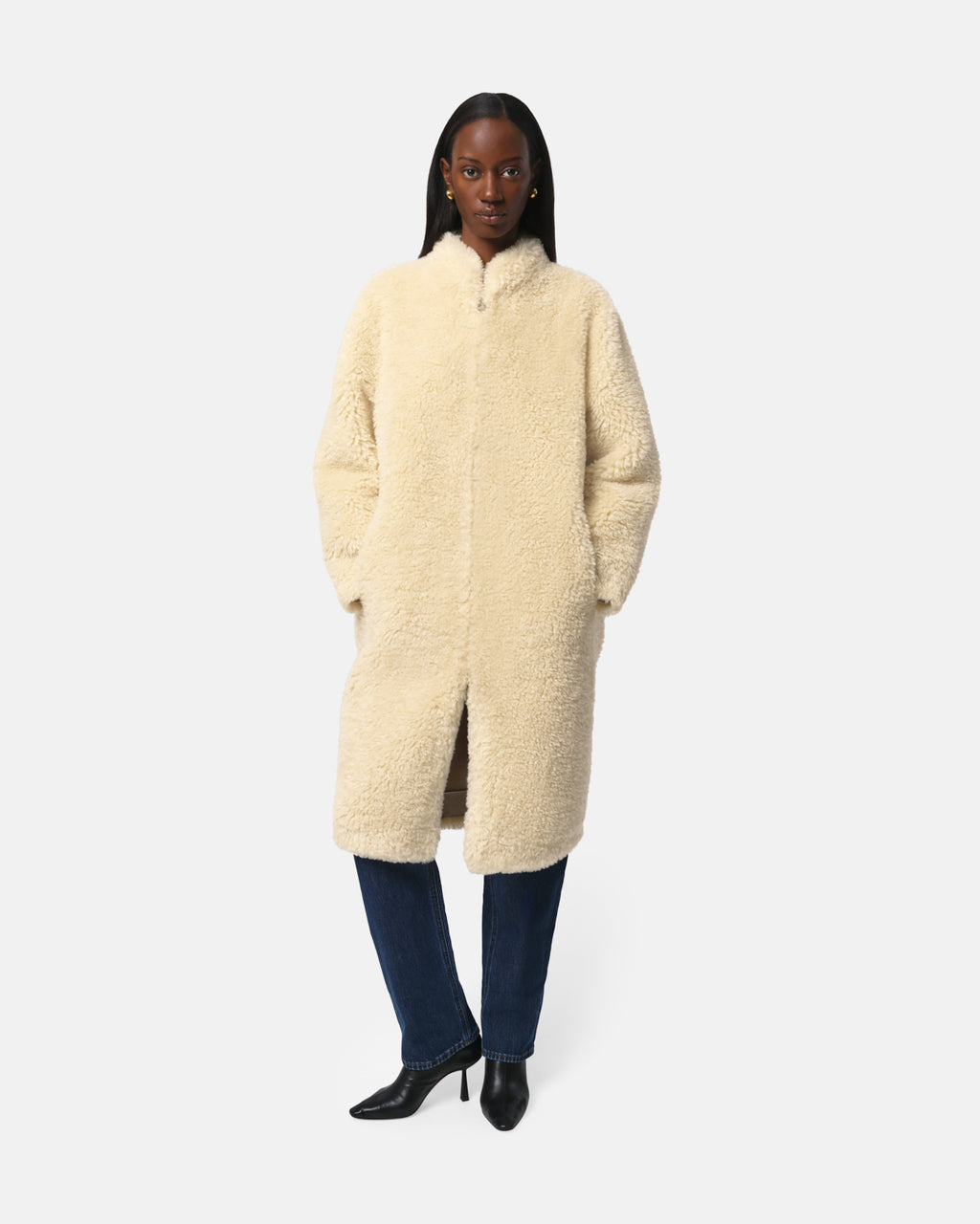 Model wearing Apparis Sylke Jacket in longline faux fur with stand collar, hook-and-eye closure, and tonal faux leather accents; sustainable outerwear made from 100% recycled polyester