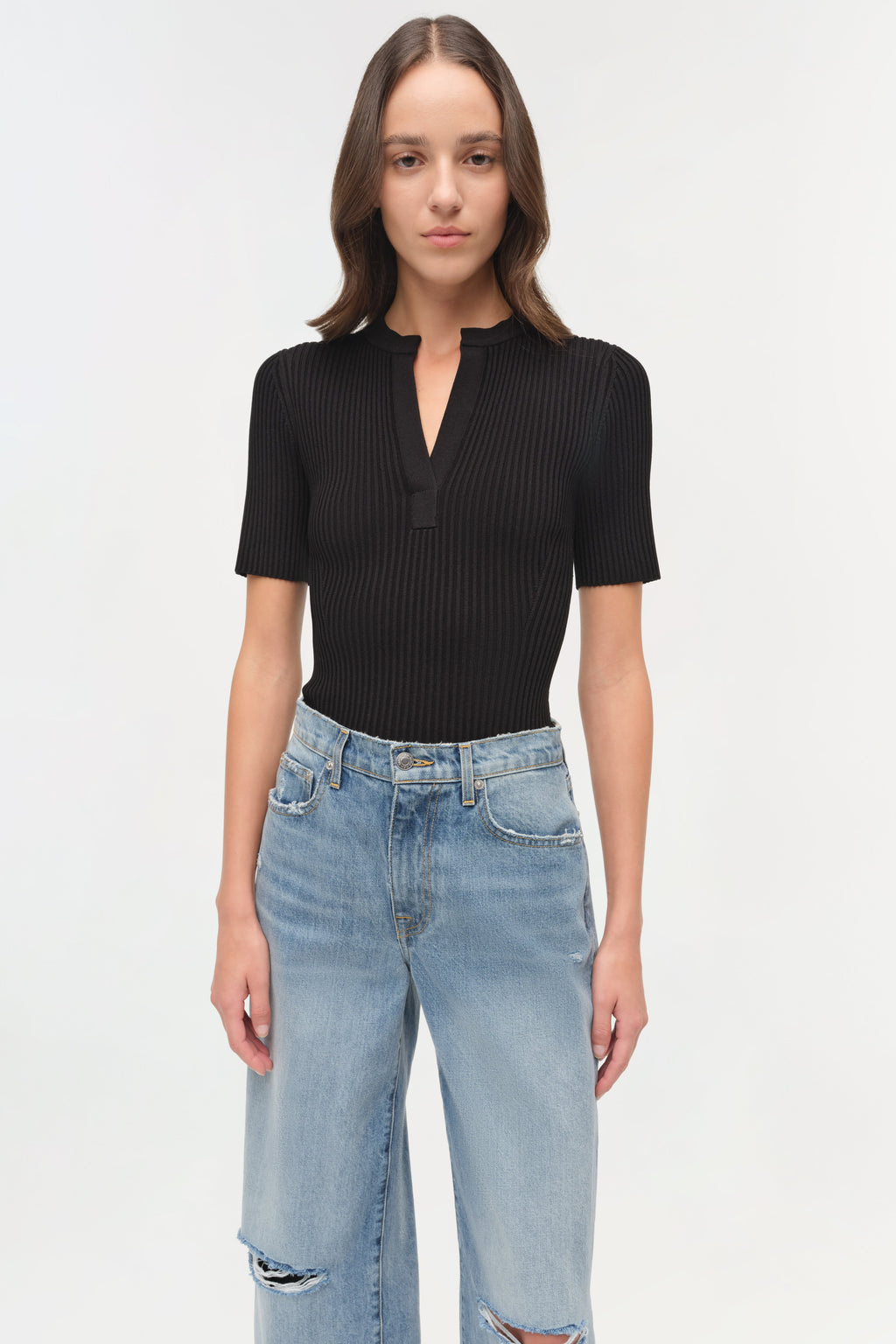 Close-up of the Simkhai Miley Knit Top in black, featuring a smooth ribbed texture, open neckline, and minimalist placket detail.