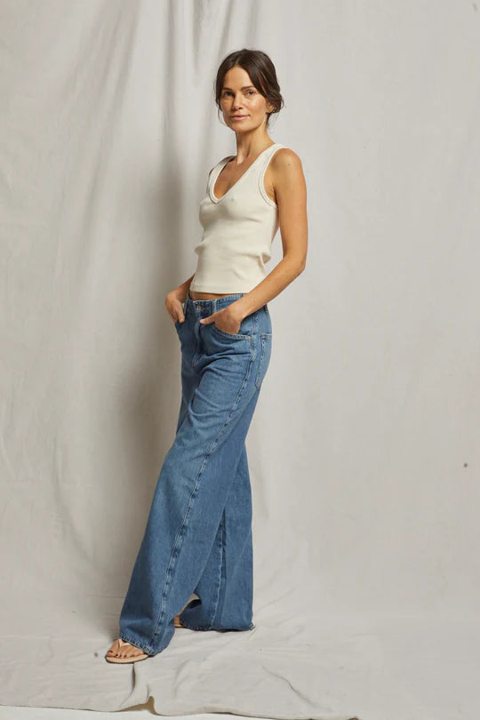 White ribbed V-neck tank top made from 95% cotton and 5% spandex, designed for a flattering fit and comfortable wear.