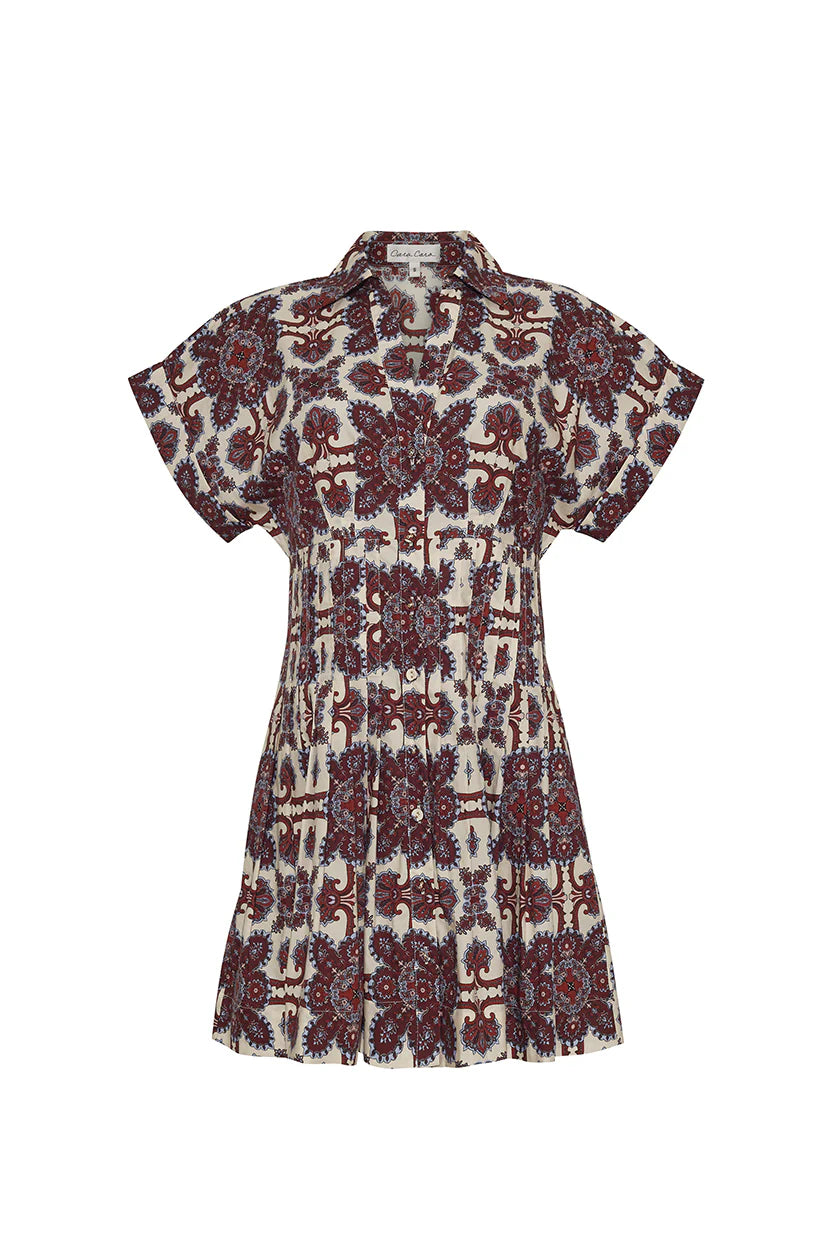 A mini-length fit-and-flare shirtdress in 100% cotton poplin, featuring a functional center front placket, side seam pockets, and pin tuck detailing at the bust and back bodice for shaping. The dress has a double-rolled cuff on the sleeves, decorative pleat at the hem, and a unique placed print. Unlined with stitching detail at the skirt yoke and bottom hem.